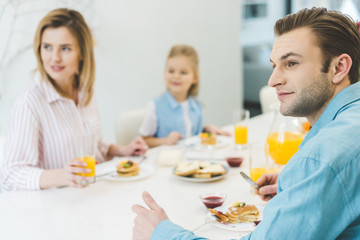 selective focus of man having breakfast together with family at home