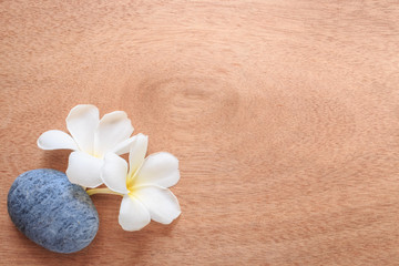 Fototapeta na wymiar Frangipani or Plumeria flower and stone zen spa on wooden plank