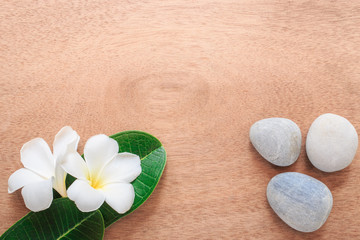 Frangipani or Plumeria  flower and stone zen spa on wooden plank