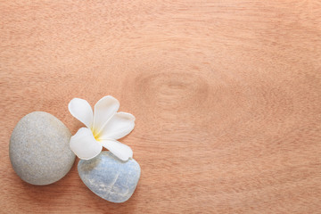 Fototapeta na wymiar Frangipani or Plumeria flower and stone zen spa on wooden plank