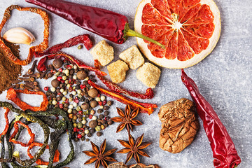 Spices on the stone gray background. Condiments on a dark table. Seasoning for cooking.