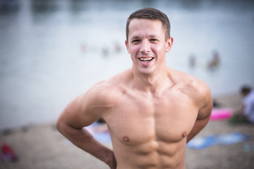 Obraz premium Young athletic caucasian man posing on the beach