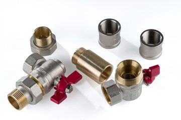 Brass corner ball valve and various brass and stainless steel sanitary fittings isolated on white background..