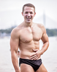 Young athletic caucasian man posing on the beach