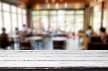 Selected focus empty brown wooden table and Coffee shop or restaurant blur background with bokeh image. for your photomontage or product display.