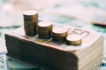 Euro coins on cash stack closeup. Financial earnings growth concept