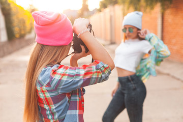The girl is taking pictures of another girl at sunset