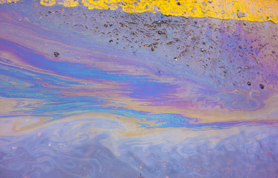 Oil Spill Rainbow Liquid on Yellow Lines on Road