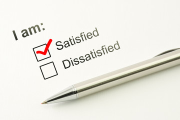 Obraz premium Satisfied choice concept. Consumer satisfaction feed back. Customer service evaluation. Marked checkbox with a pen on paper background