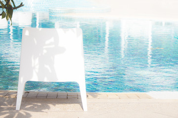 Fototapeta premium White chair next to the pool.