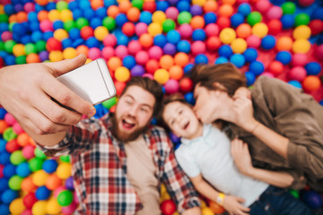 Obraz premium Happy little child have fun with his parents make selfie