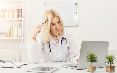 Portrait of upset doctor sitting at the desktop