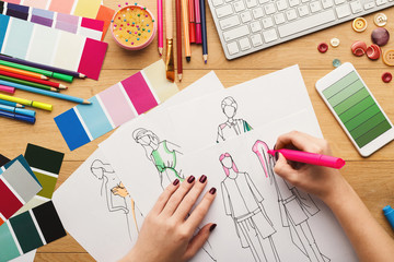 Fototapeta na wymiar Top view on woman designer drawing clothes sketches