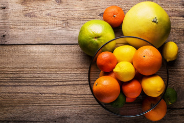 Fototapeta na wymiar fresh citrus fruits in a glass bowl, top view