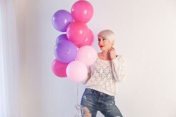 blonde girl with gifts and balloons for the birthday