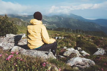 Fototapeta premium Alone tourist in yellow jacket sitting in high mountains. Landscape photography