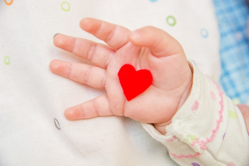 Baby  holding a heart.