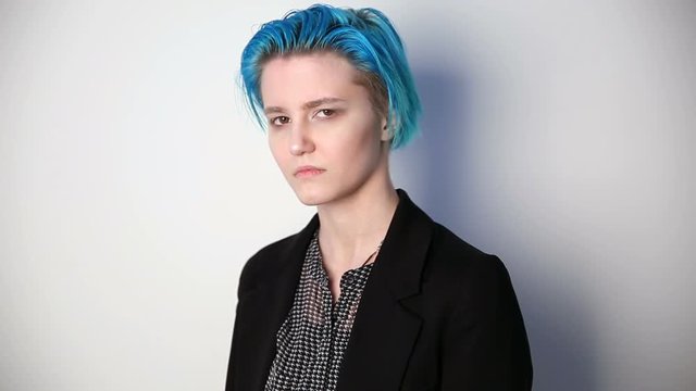 modern youth. calm portrait of a serious girl of unusual appearance with blue hair.