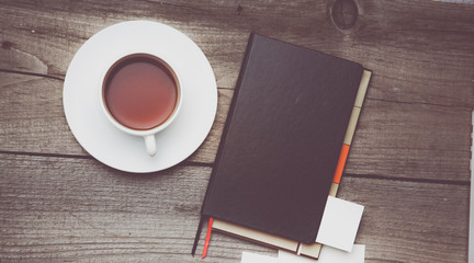 Blank business cards with pen, notebook and tea cup on wooden office table