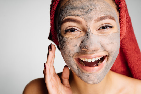 happy smiling girl has put a useful clay mask on the face