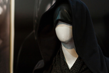 a dummy woman in a black hood is in the store