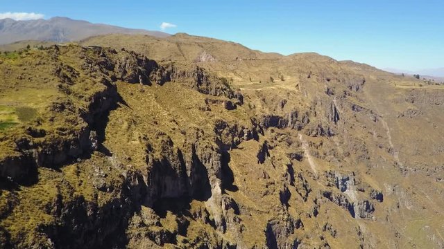 Drone aerial flying slowly towards the edge of the valley in the Colca Canyon in Peru on a sunny day