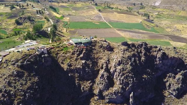 Cinematic drone aerial flying towards a beautiful home overlooking the cliff of the Colca Canyon in Peru