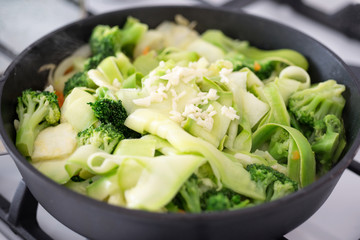 Fresh green vegetables stewed in a frying pan