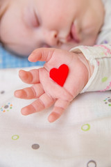 Baby  holding a heart.