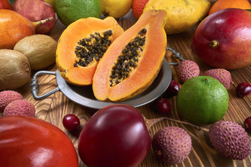 Owoc papaja na cynowej misce, wokół dużo owoców innego gatunku 
