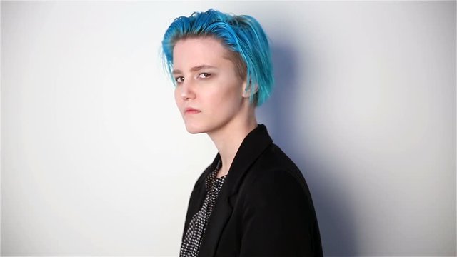 modern youth. calm portrait of a serious girl of unusual appearance with blue hair.