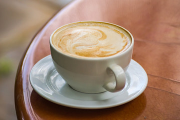 Simple cappuccino on a brown round table in a tropical garden in Nairobi Kenya