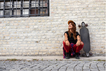 Cute trendy urban girl with longboard outdoors