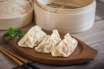 Steamed dumplings on wooden plate