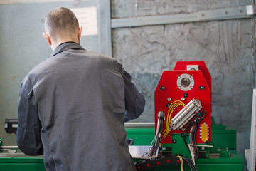 Electrician works with parts of energy equipment on plant