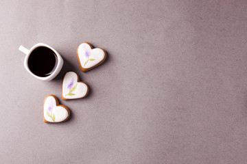a cup of espresso and a group of cookies with aysing in the shape of a heart on a gray background, conciseness, minimalism