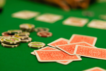 Poker cards and chips on green table