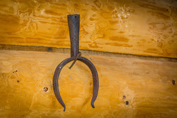 Iron tongs for the pot hanging on the wall