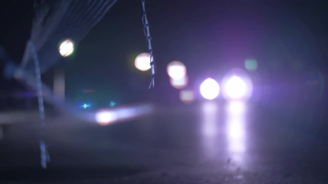 Slow Motion Shot Of Cars Driving In The Street At Night And Flashing With Bright Headlights