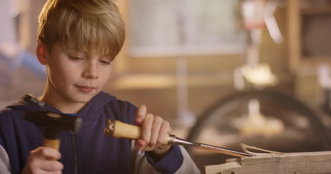 Boy is carving some notches into a wooden plank