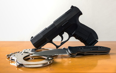 Obraz premium Tactical gear set of 9mm Pistol gun knift handcuff and clock on wooden with isolated white background. Police or military equipment concept.