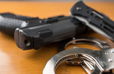 Tactical gear set of Pistol gun knift handcuff and clock on wooden background. Police or military...