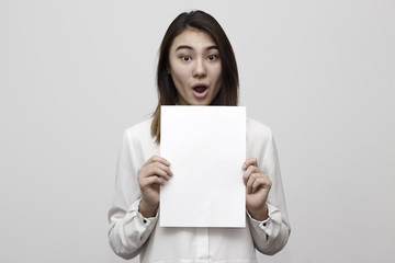 Shocked young girl holding empty blank white board. Leaflet presentation. Pamphlet hold hands. Girl...