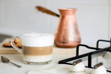 Home made coffee latte, tea spoon, coffee pot, cookies, for breakfast, kitchen interior, cook top