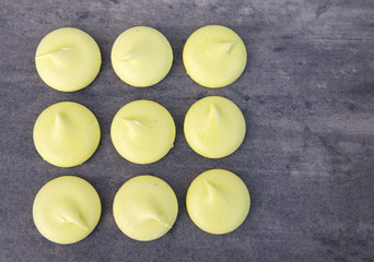 Green meringues with copy space on a grey background