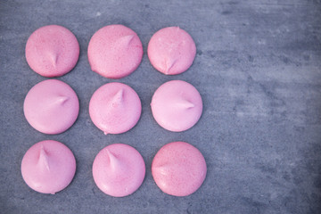 Obraz na płótnie Canvas Pink meringues with copy space on a grey background