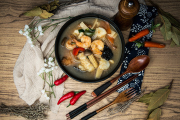 Bowls of Asian soup noodles and seafood with Chopstick