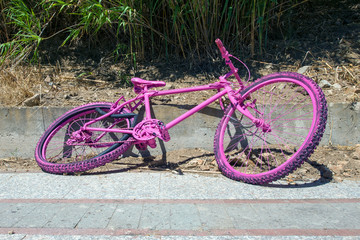 A pink broken bike