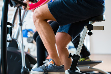 Group of men doing workout on exercise bike at gym
