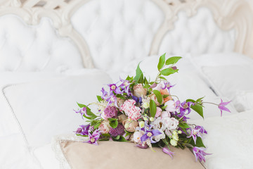 Bouquet of flowers on the pillow, gentle tones.